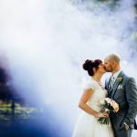 West Mill Derby wedding bride and groom against a background of coloured smoke whilst kissing