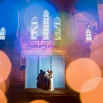 bride and groom standing in front of Fazeley Studios at night